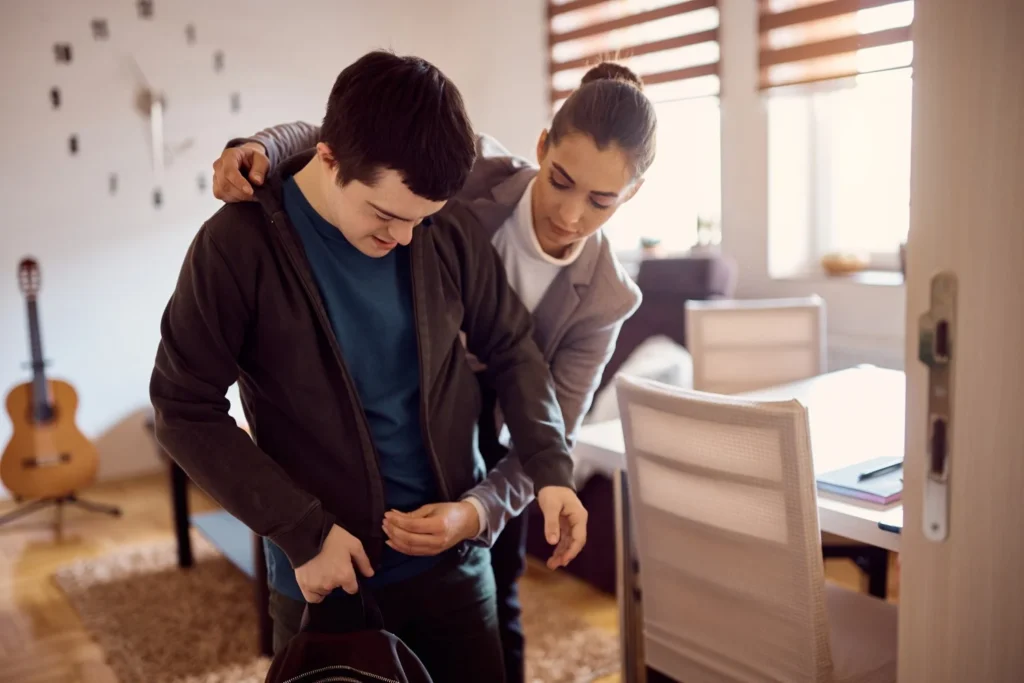 Disabled man getting dressed with help of support worker