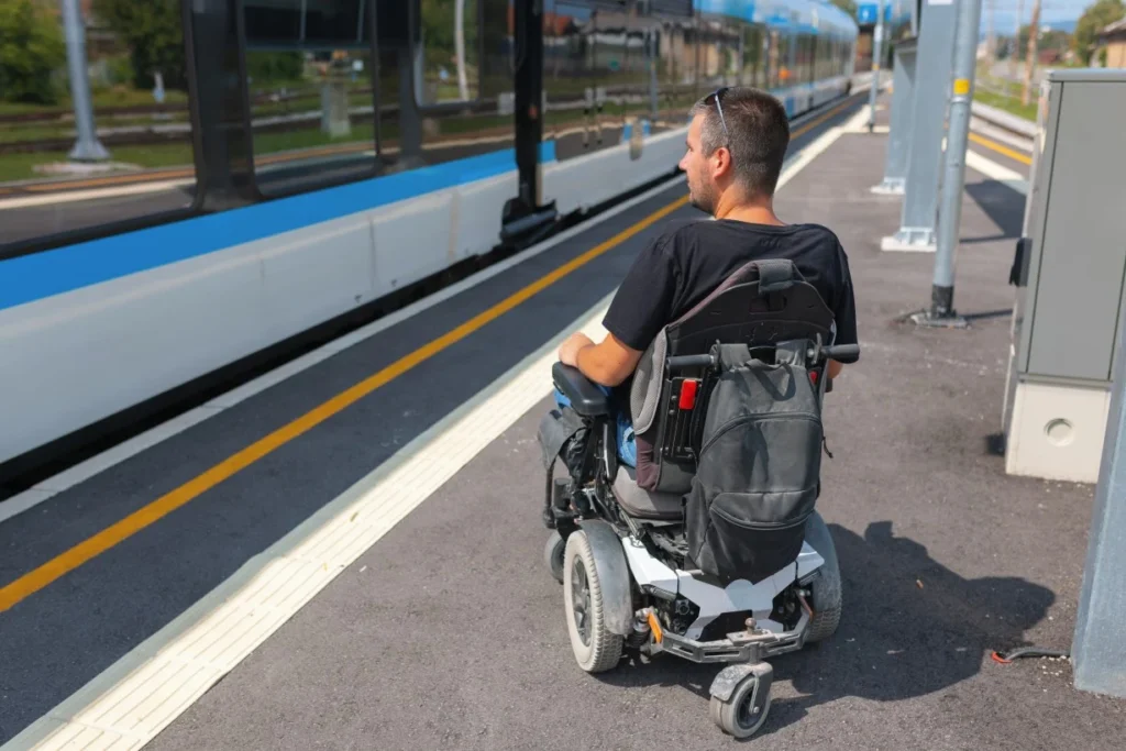 Disabled man in wheelchair waiting on train platform